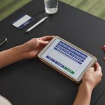Pessoa utiliza um tablet durante um procedimento de registo eleitoral.